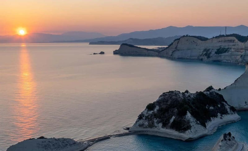 Corfu: Palaiokastritsa Swimming and Loggas Beach Sunset Tour - Loggas Beach sunset at Peroulades: limestone cliffs do the drama